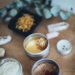 A serene arrangement of bath salts, candles, and natural ingredients on a wooden table for a relaxing self-care ritual.