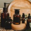Aesthetic arrangement of amber glass bottles with a rustic backdrop, perfect for beauty product showcasing.