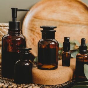 Aesthetic arrangement of amber glass bottles with a rustic backdrop, perfect for beauty product showcasing.