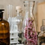 Glass bottles and test tubes with pink flowers, symbolizing natural aromatherapy and wellness.